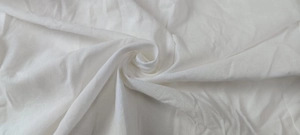 Detailed macro shot of white plain weave cotton fabric texture on casual shirt and shorts set