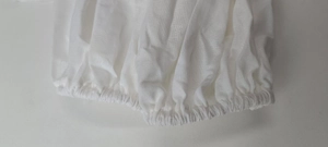 Detail of white cotton-linen blouse showing elasticated gathered cuffs and textured fabric