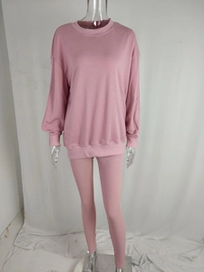 Detail of pink lounge set featuring drop shoulder sweatshirt and ribbed slim-fit pants