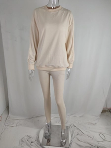 Detail view of beige ribbed knit lounge set featuring round neck sweatshirt and slim pants