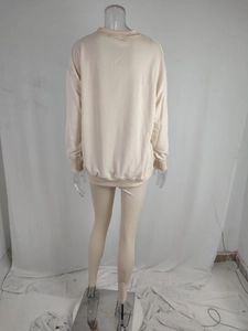 Rear view of beige ribbed long sleeve sweatshirt and slim matching pants set on mannequin