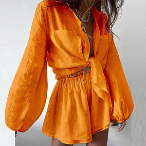 Vibrant orange two-piece linen set with button-down shirt and ruffled shorts for women