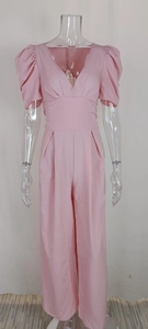Detail of pink elegant wide leg jumpsuit featuring V-neckline and puffed short sleeves