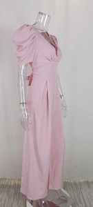 Detail of high waist pleated jumpsuit in light pink with elegant V-neck and puff sleeves