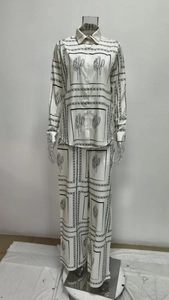 Detail of long-sleeved button-up shirt and wide-leg trousers with cactus print pattern
