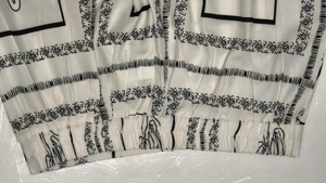 Detail of elastic waist band and black geometric floral print on lightweight fabric