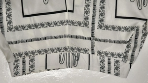 Detailed view of the black and white cactus print on soft chiffon shirt fabric