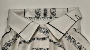 Close-up of shirt collar with geometric floral print and a pearlescent button detail
