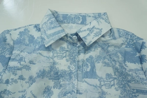 Detailed view of white long-sleeve shirt with blue landscape toile de jouy print