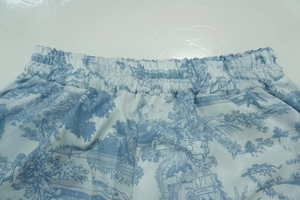 Detail of elastic waistband on light blue Toile de Jouy print trousers with classical patterns