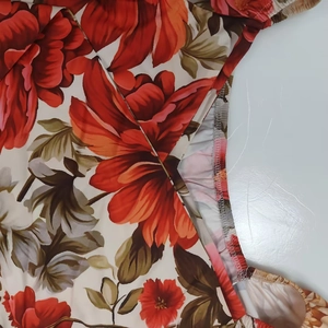 Dettaglio dell'elegante motivo floreale con bordi a balze su un abito in chiffon a V