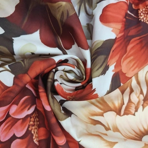 Dettaglio del tessuto a fiori con boccioli rosso scuro e consistenza drappeggiata