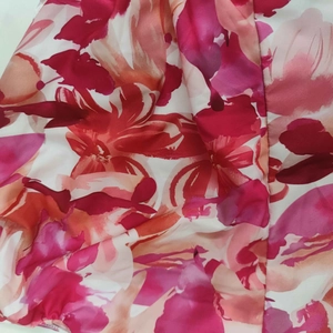 Detailansicht des lebhaften Blumenmusters in Rosa und Orange mit dezentem Glanz