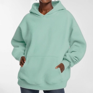 Macro detail of mint green oversized hoodie featuring loose knit fabric and kangaroo pocket