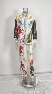 Detail of artistic graffiti print on white long sleeve shirt and wide leg trousers set