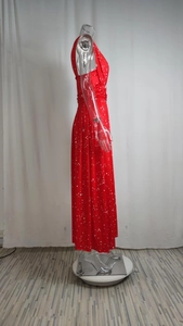 Détail d'une robe maxi rouge sans manches avec motifs étoiles et pois blancs sur un mannequin