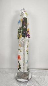 Detail of printed casual set showing artistic sun and snake motifs on satin fabric