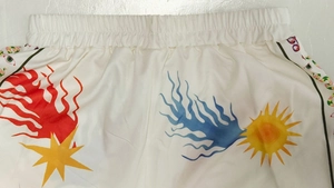 Close-up of vibrant abstract flame print on white elastic waistband shorts