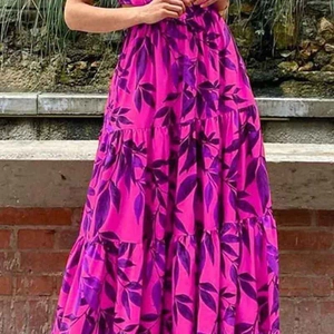 Dettaglio del vestito lungo a balze a vita alta con stampa di foglie viola su fucsia