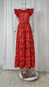 Dettaglio del vestito lungo floreale rosso con gonna a balze e stampa di foglie viola