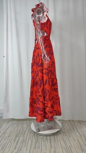 Dettaglio dell'abito lungo rosso con stampa tropicale, maniche a farfalla e gonna a balze
