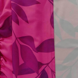 Dettaglio del tessuto con motivo a foglie in tonalità magenta e verde petrolio