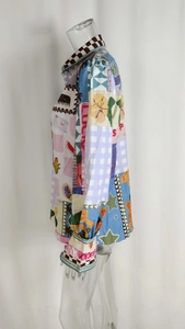 Detail of colorful patchwork print shirt with floral patterns and 'LUCKY' text design