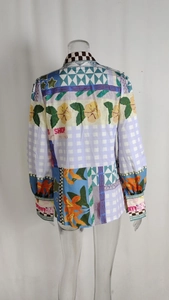 Detail view of the back of a multi-pattern printed long sleeve blouse with mixed patch designs