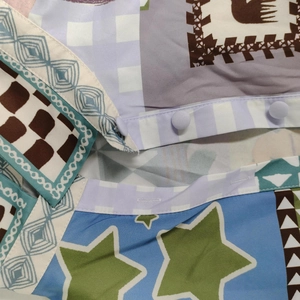Detailed macro shot of fabric stitching with colorful star prints and a lavender button