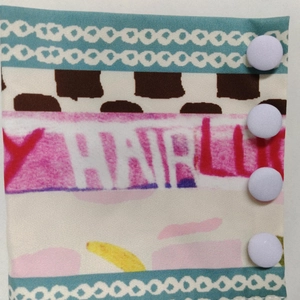 Macro shot of colorful printed fabric detail with four white resin snap fasteners on the side