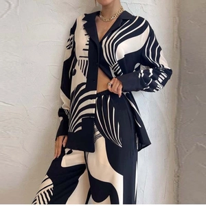 Detailed view of women's long-sleeve shirt and trousers set with black white geometric print