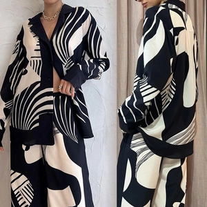 Detail of high-waist wide-leg pants and button-down shirt with black white abstract print
