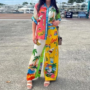 Detail of vibrant tropical prints on resort-style short-sleeved shirt and wide-leg trousers