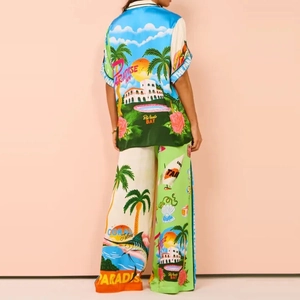 Detail of tropical island print on satin shirt and trousers with Paradise Inn text