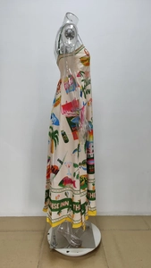 Detail of tropical print maxi dress with Paradise Inn text and vibrant vacation motifs