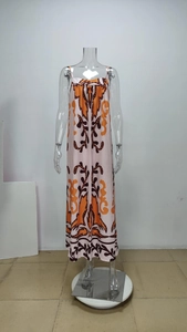 Detail of high-waist maxi dress featuring orange ethnic graffiti prints and thin straps