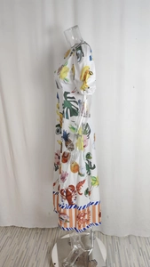Vue latérale d'une robe blanche à manches courtes avec imprimés tropicaux et fruits de mer
