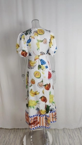 Détail de la robe imprimé tropical avec motifs de fruits et bordures colorées au bas