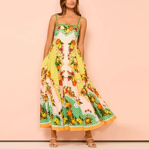 Detail of vibrant tropical fruit print on elegant high waist spaghetti strap maxi dress