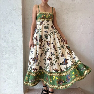 Detailed view of the vibrant bird and floral print on a white boho midi dress with green trim