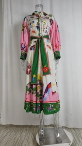 Détail de la robe chemise bohème avec motifs mystiques et ceinture verte contrastée