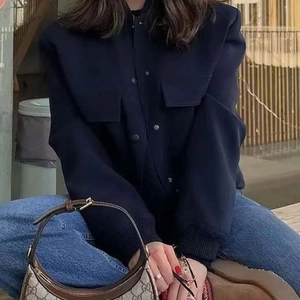 Elegante chaqueta corta azul marino con bolsillos de solapa y puños acanalados