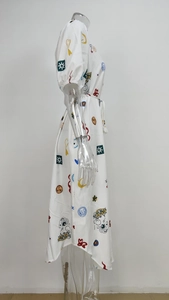 Détail d'une robe midi blanche à manches bouffantes, imprimé graffiti surréaliste et lien à la taille