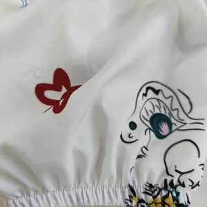 Détail de la taille élastique sur robe blanche imprimée avec cœur et motifs cartoon