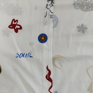 Vue détaillée de la texture du tissu et des imprimés soleil papillon sur robe blanche
