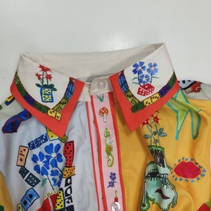 Détail d'une robe vintage à manches lanternes avec imprimé surréaliste et col rouge