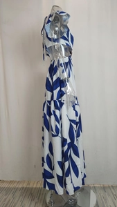 Détail d'une robe longue à fleurs bleues avec jupe à volants et bretelles volantées