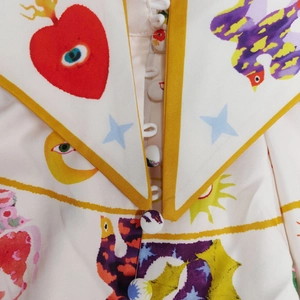 Detail of surrealist art print on shirt collar with bird motifs and cloth buttons