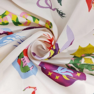 Detail of soft white fabric with vibrant colorful prints and smooth silk-like texture
