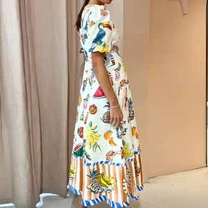 Motifs tropicaux de toucan et fruits sur une robe longue blanche à manches bouffantes